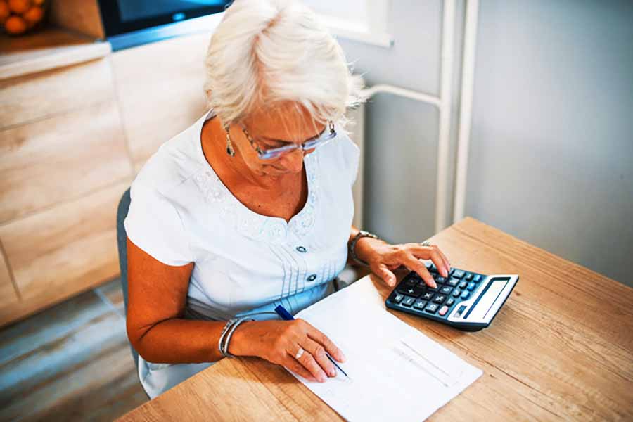 mujer mayor hace cuentas con calculadora