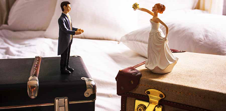 novio y novia sobre una maleta cada uno se divorcian